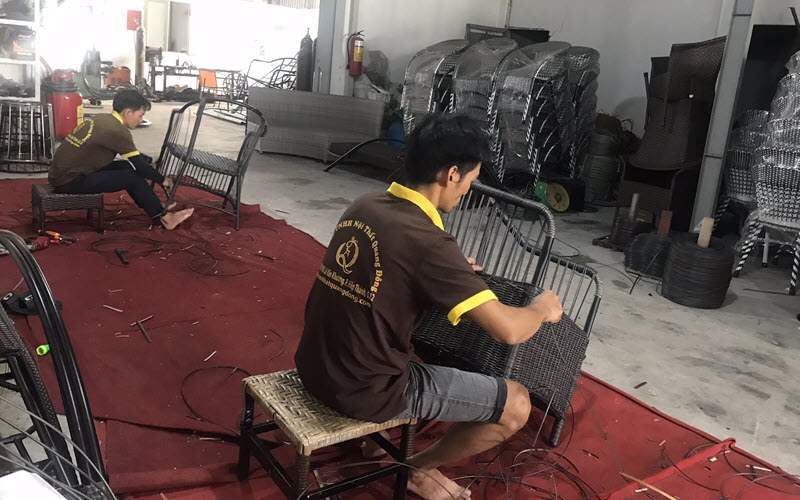 Hình ảnh người thợ tiến hành đan lại ghế giả mây